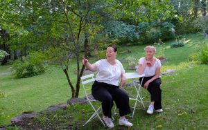 Teatterikoneen Annu Sankilampi ja Kirsi Sulonen istuvat Villa Ranan puutarhassa ennen Wivi ja Hanna -näytelmää